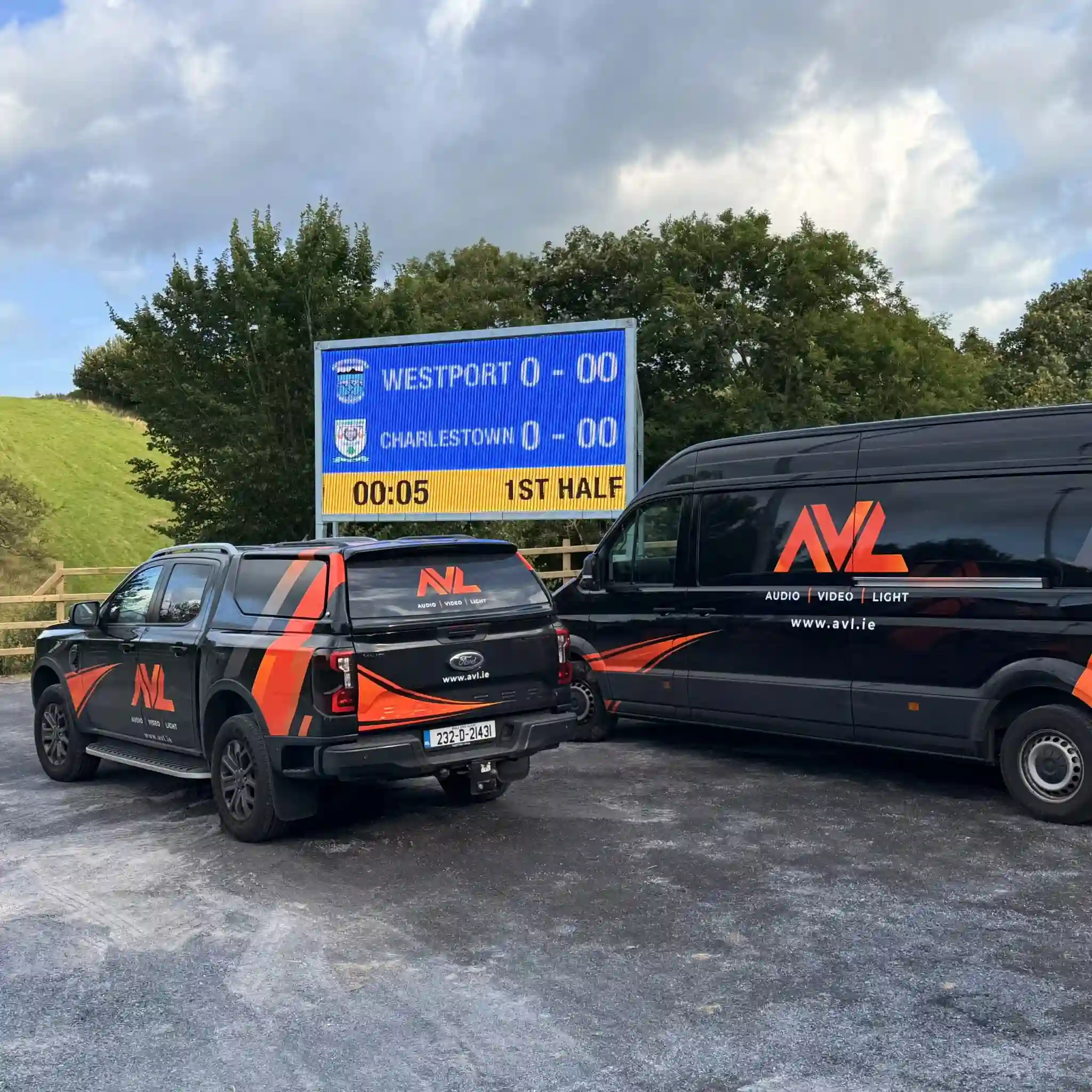 Two AVL Vehicles Standing Aside the Scoreboard Installation
